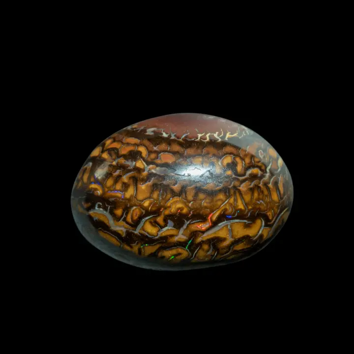 Natural Australian Koroit opal cabochon, 13.7 carats, with finely decorative patterns studded with brilliant red and green flakes.