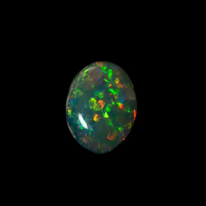 Opale naturelle australienne des mines de Lightning Ridge, petit ovale de 0,4 carats de cristal sombre aux éclats oranges et verts très brillants
