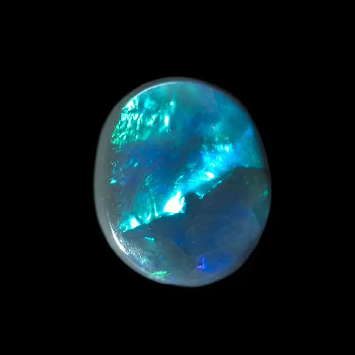 Natural Australian black opal from the Lightning Ridge mines, small cabochon of 0.4 carats with a blue-green luster of intense luminous intensity on half its surface, dark blue on the other half.