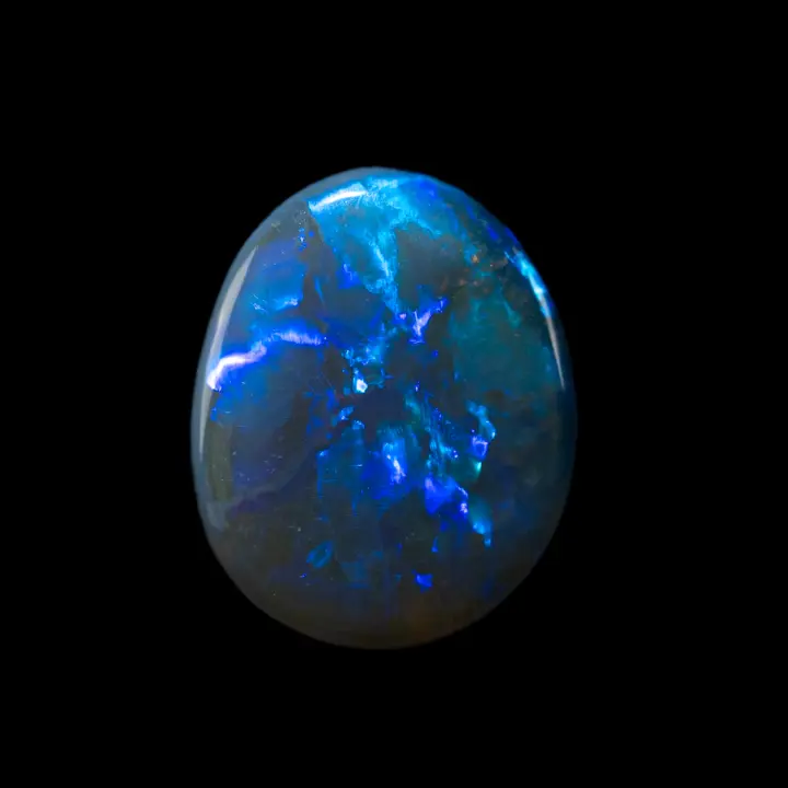 Opale naturelle australienne noire des mines de Lightning Ridge, cabochon de 1,7 carats à brillances intenses bleues en rayons autour d'un axe central à la pierre