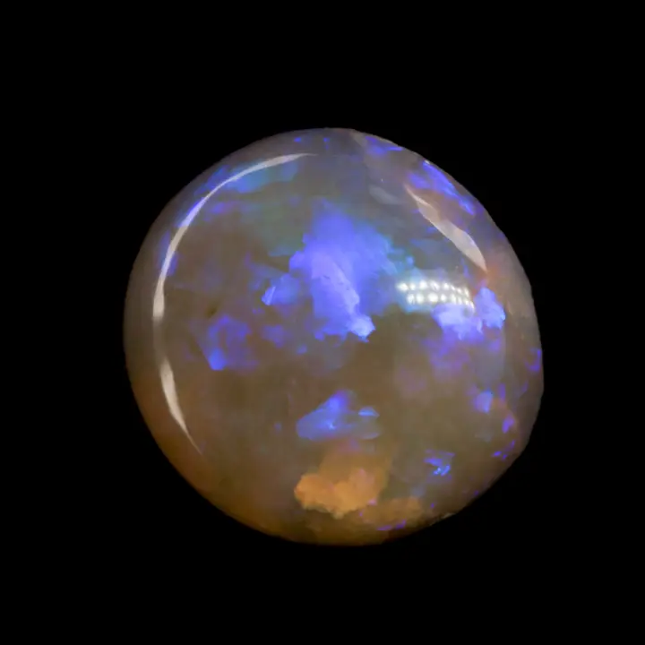 Opale naturelle australienne des mines de Lightning Ridge, cristal clair très transparent de forme presque ronde, à matrice orangée et brillance violette