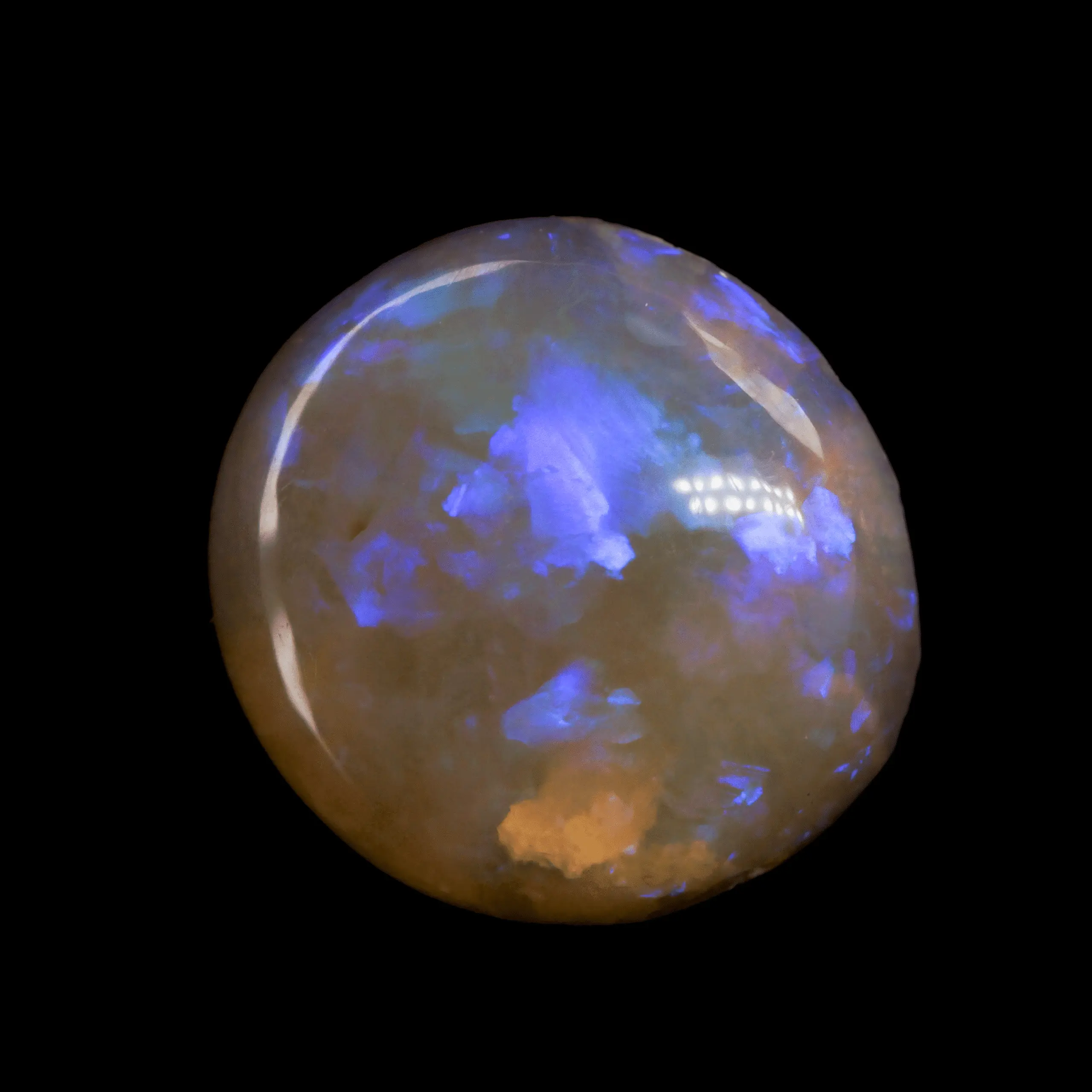 Opale naturelle australienne des mines de Lightning Ridge, cristal clair très transparent de forme presque ronde, à matrice orangée et brillance violette