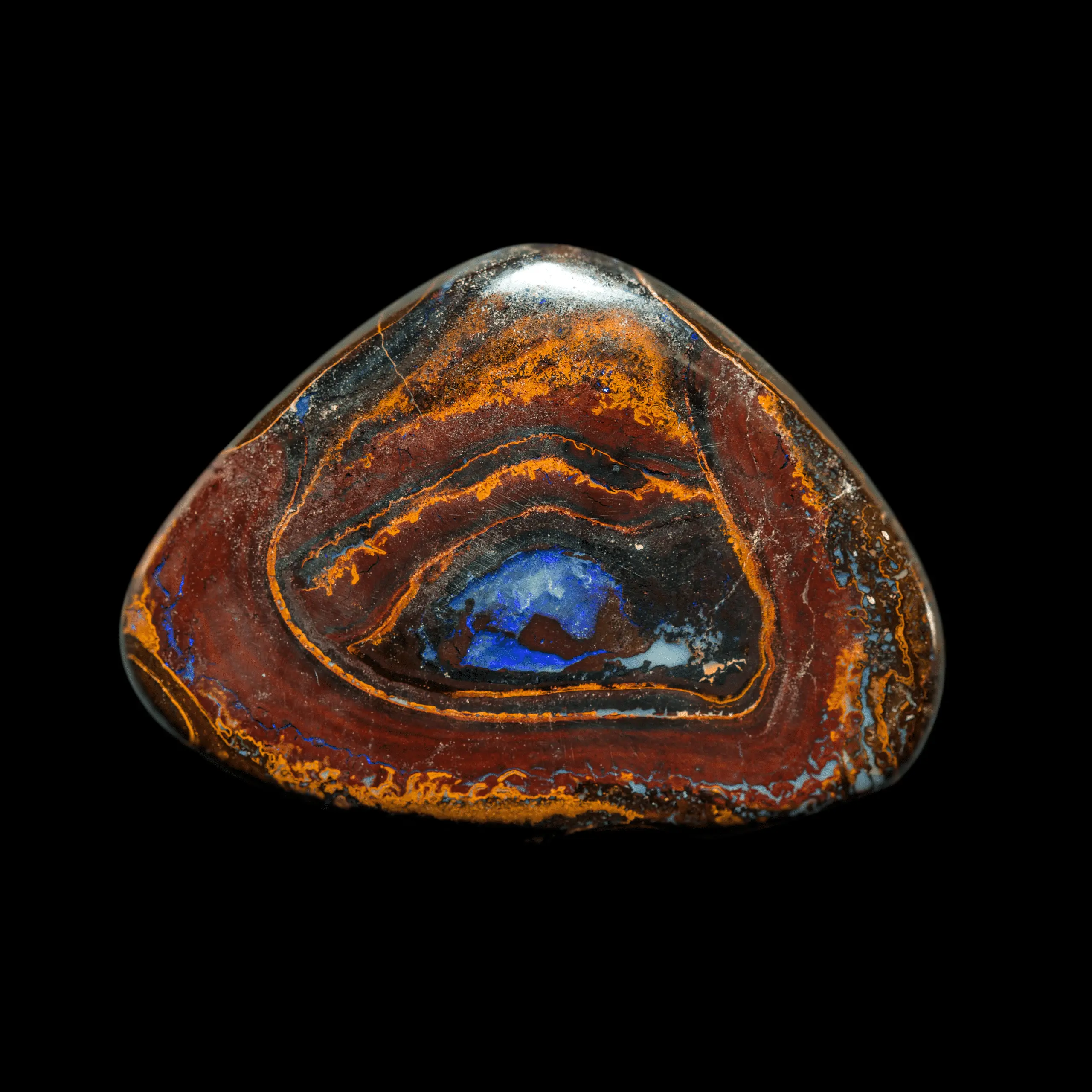 Opale naturelle australienne Koroit, grande forme triangle de 71,50 carats aux contours décorés de couleurs ocres sur fond rouge cardinal agrémenté d'un grand oeil central à la brillance bleue-violette