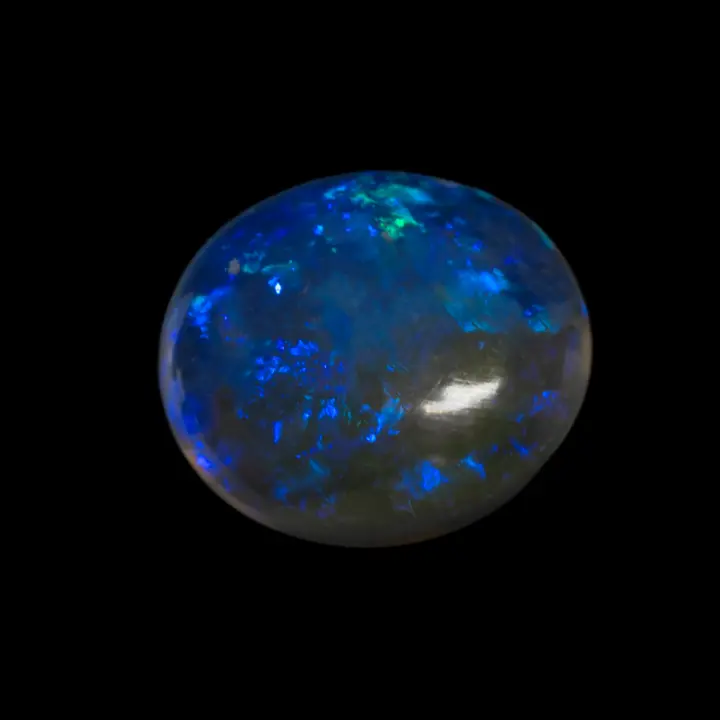 Natural Australian white crystal opal from the Lightning Ridge mines, 1.3-carat cabochon, highly transparent, colored with blue flashes and polished on both sides.