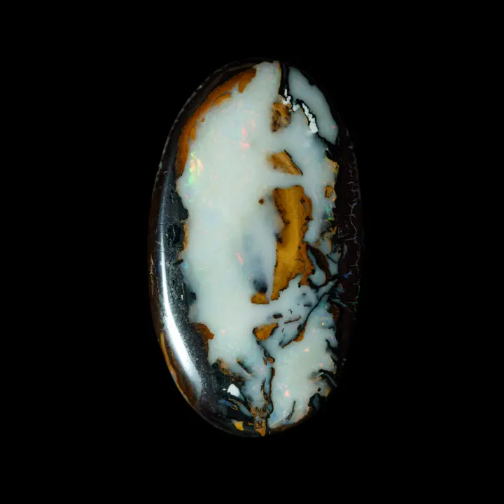 Natural Australian opal from the koroit mines, free form 36.5 carats resembling a strongly opalized white walnut with multicolored diffraction on a dark background.