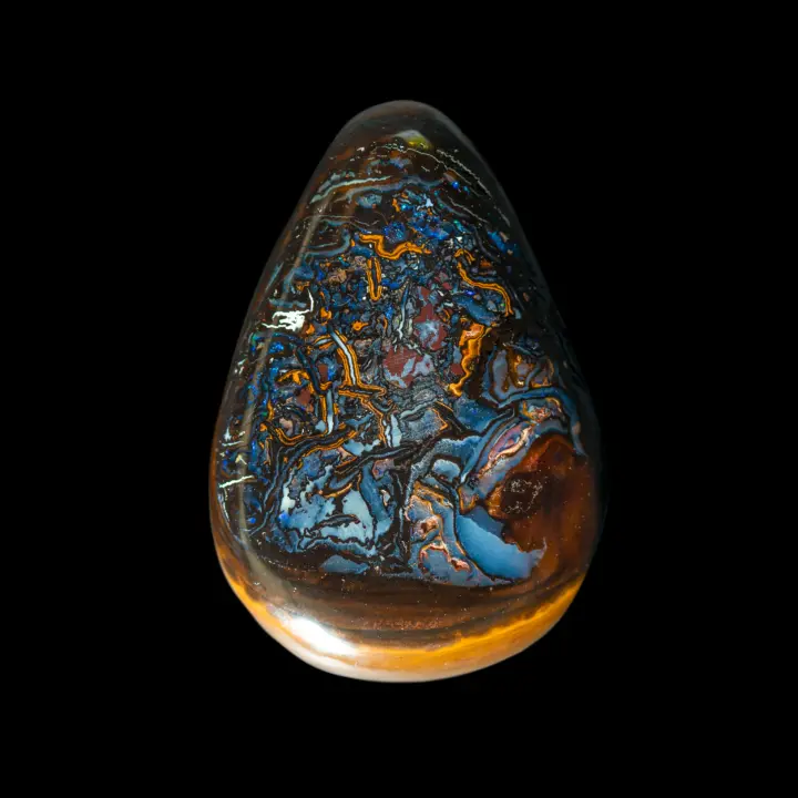 Natural Australian opal from the Koroit mines, 33.3 carats cut into a highly decorative teardrop shape with blue and yellow geometric patterns sprinkled with a few small green and violet flakes.