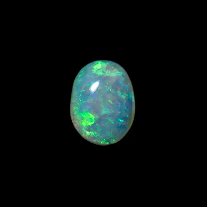 Natural Australian opal from the Coober Pedy mines, 0.9 carat clear crystal cabochon with predominantly light green brilliance brightened by a little blue and a hint of orange.