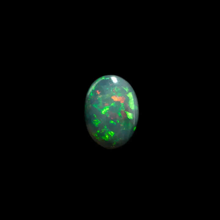 Natural Australian opal from the Lightning Ridge mines, cabochon of 1.8 carats, predominantly red and green but not only; strong orange, blue and yellow flashes sometimes follow the green and red.