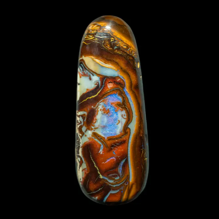 Natural Australian opal from the Koroit mines; 21.7-carat free-form shuttle with highly colored and contrasting art deco motifs, opalized in the center with a bluish brilliance.