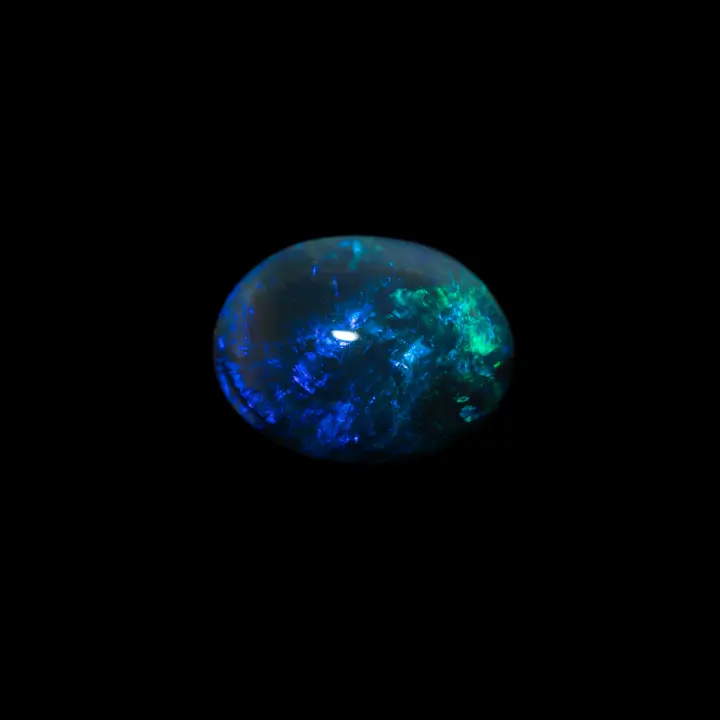 Natural Australian opal from the Lightning Ridge mines, 1.5 carat oval black opal of a beautiful blue dotted with soft green.