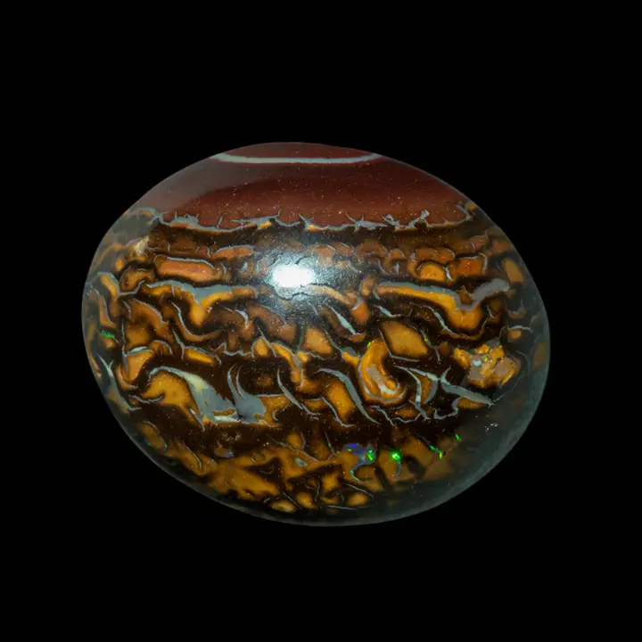 Natural Australian opal from the Koroit mines, 16.5 carat cabochon with ochre, yellow and brown ring decoration embellished with a clear ring on a bistre background and small green, violet and red coloured brilliants.
