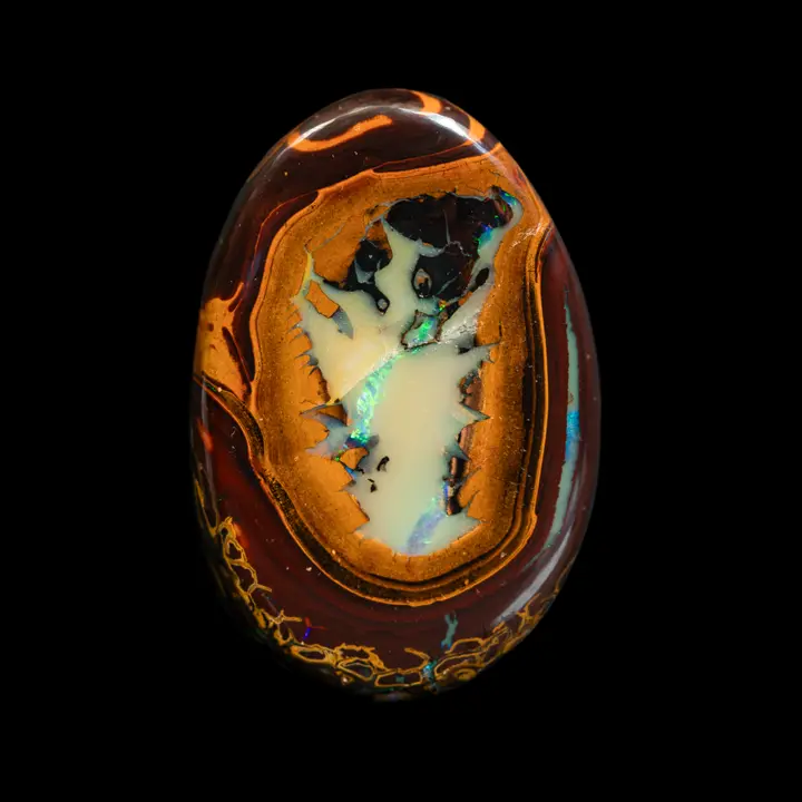 Natural Australian Koroit opal, flat oval cabochon in 53.7 carat medallion, finely decorated in contrasting colours and ring lines around an opalized centre with blue-green brilliance