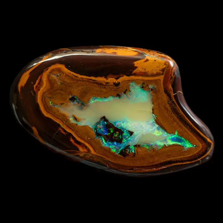 Natural Australian opal from the Koroit mines, remarkable free form of 34.1 carats with red and yellow ochre matrix enclosing a lagoon of green and blue brilliance.