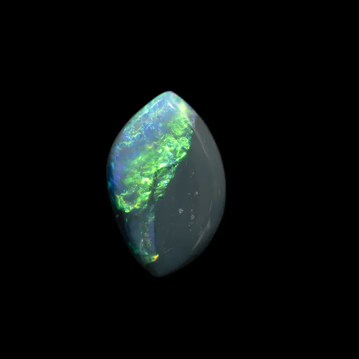 Natural Australian black opal from the mines of Lightning Ridge, 1.5 carat shuttle shape taking up the visual of the symbolism of traditional Chinese thought with a Yang illuminated by a green and blue iridescence