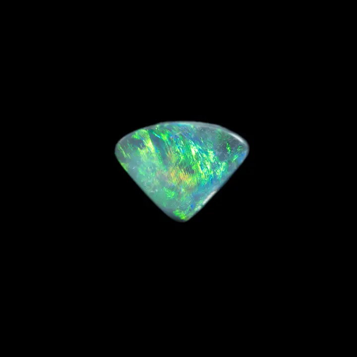 Natural Australian opal from the Lightning Ridge mines, a small triangular crystal of 0.8 carat with a charcoal grey matrix and a generalized green-yellow brilliance punctuated with a little blue
