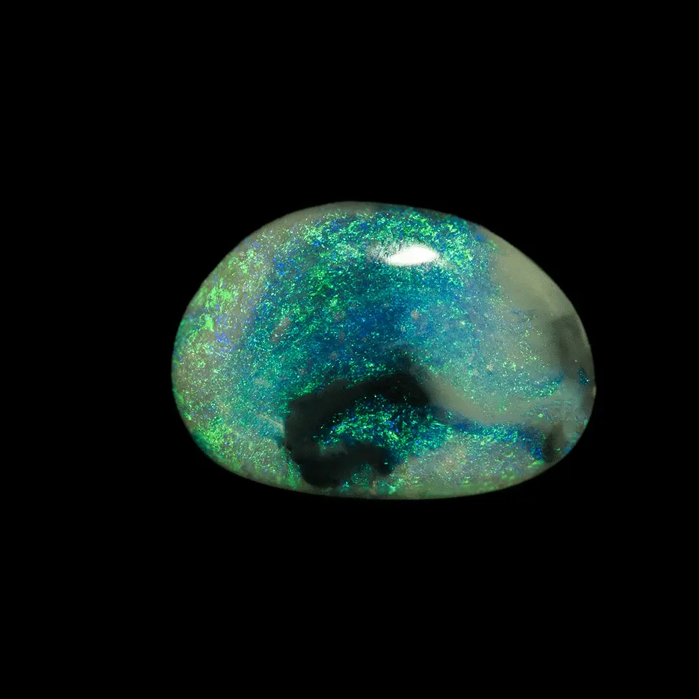 Opale naturelle australienne cristal des mines de Lightning Ridge, forme libre en haricot de 1,7 carat, polie sur une face, à matrice transparente virgulée de noir, colorée de vert et bleu en brillances mousseuses