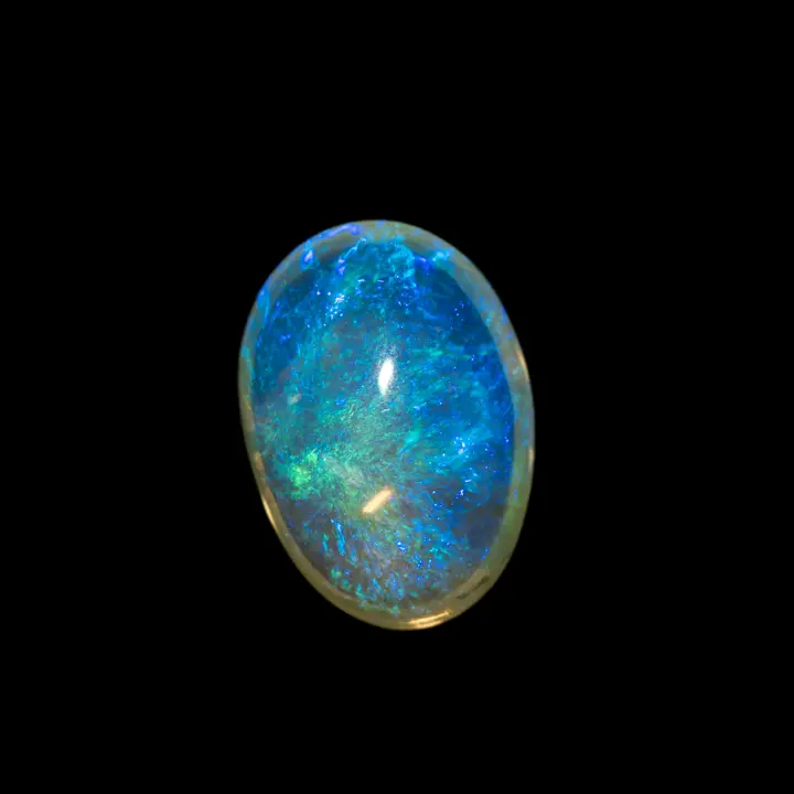 Opale naturelle australienne des mines de Lightning Ridge, cristal de 2,1 carats poli sur ces deux faces. Matrice très transparente et irisations bleues-vertes en volutes encapsulées