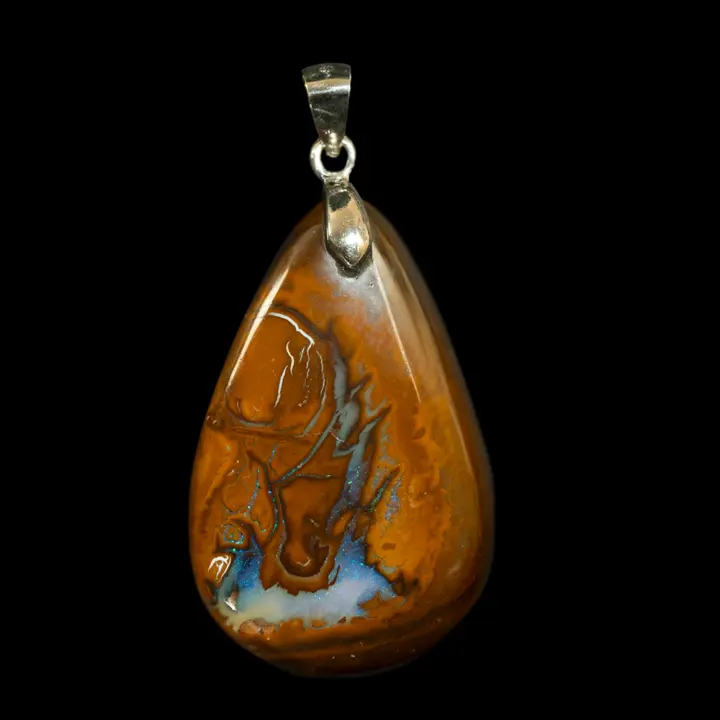 Natural Australian opal from the Koroit mines, 34.5 carats, mounted as a pendant on a 925 silver bezel, the iridescent blue zone evokes the sea breaking over the rocks in brilliant waves, caramel ochre matrix.