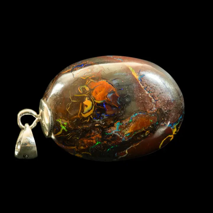 Natural Australian opal from the Koroit mines, 32.5 carat ovoid opal mounted on a 925 silver bezel and polished on both sides; its dark matrix highlights its iridescence and areas of vivid hues.