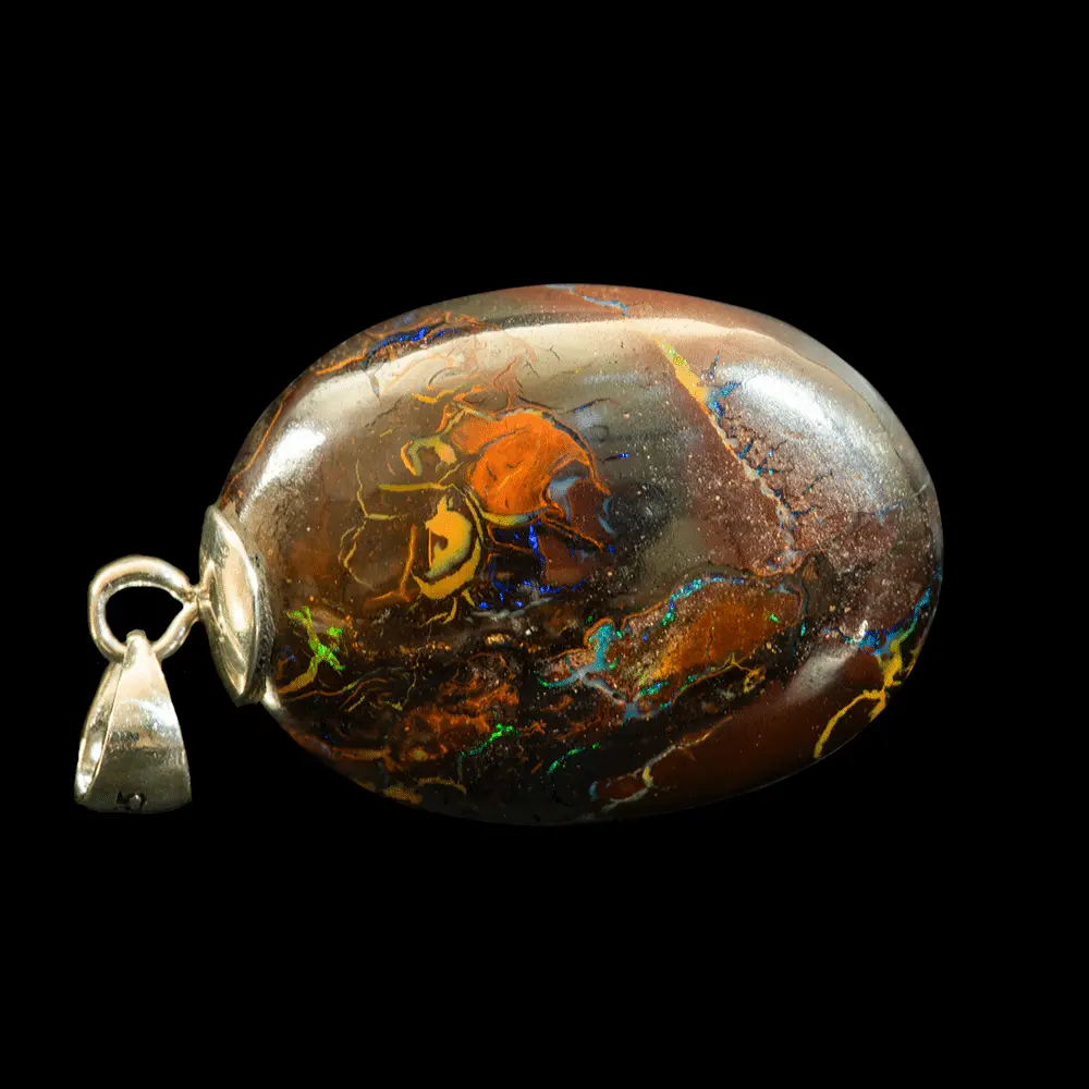 Natural Australian opal from the Koroit mines, 32.5 carat ovoid opal mounted on a 925 silver bezel and polished on both sides; its dark matrix highlights its iridescence and areas of vivid hues.