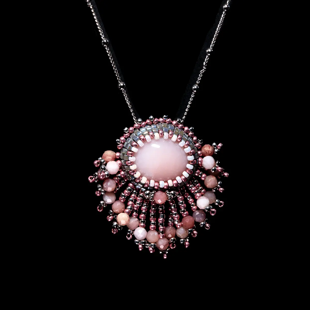 Cabochon ovale d’opale rose naturelle (8,4 cts) du Pérou, serti en tissage péyote avec des perles en verre Miyuki Délicas, des perles de rocaille et des perles rondes d’Opale rose. Chaine maille gourmette et fermoir en argent 925 rhodié, collier de longueur 448 mm.
