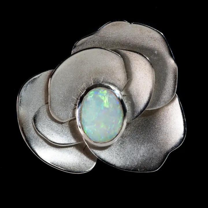 Opale naturelle australienne des mines de Coober Pedy, cabochon d'opale claire cristal de 1,3 carat à irisations vertes et violettes montée en pendentif sur sépales d'argent 925 rhodié, la corolle d'argent et l'opale ont la finesse et la brillance de la soie ainsi que la noblesse de l'opale blanche australienne