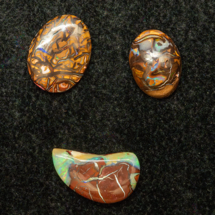 Lot de trois opales naturelles australiennes des mines Koroit de 16,9 carats avec une réduction de prix appliquée de 30%. Le lot se caractérise ainsi : l'opale Koroit  KOR17-014 (4,9 carats de dimensions 18,2x10,7x3,3mm) , en forme de demi poire inversée évoquant un demi cœur de 4,9 carats, matrice grenat soulignée de blanc et encadrée d’une zone très irisée bleu vert l'opale Koroit zébrée KOR17-009 (6,1 carats de dimensions 16,6x12,6x3,5mm) à matrice brun-orangé zébrée de lignes noires et fines lignes irisées vertes, multicolores, violets, rouges le cabochon d’arène d’opale Koroit KOR17-001 (5,9 carats de dimensions14,0x10,5x5,4 mm), matrice brune et ocre constellée d’aplats et lignes irisées à dominante bleu et vert