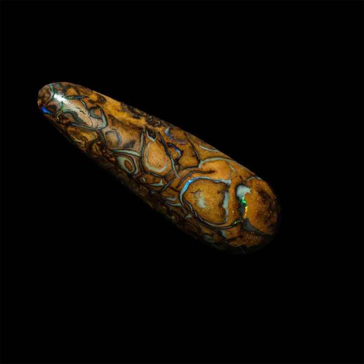 Opale naturelle australienne des mines Koroit. Forme de larme fine de 9,4 carats à matrice ocre jaune sillonnée de tracés sombres ou clairs de matrice iridescentes bleue, verte et orange.