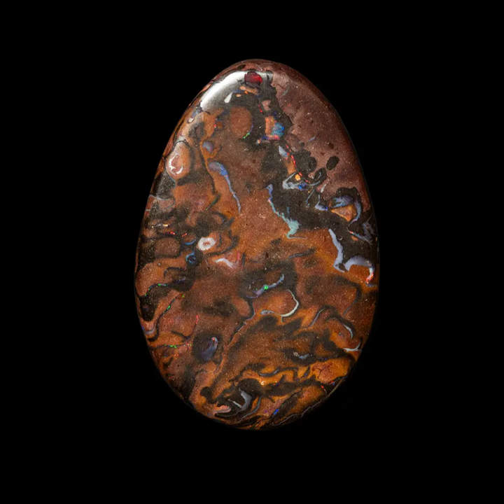 Opale naturelle australienne des mines Koroit. Cabochon ovalisé de 17,8 carats, matrice à variations de teintes marron acajou, noisette et brou de noix, les veines irisées colorées sont joliment reparties et donnent beaucoup d’élégance à ce joli cabochon